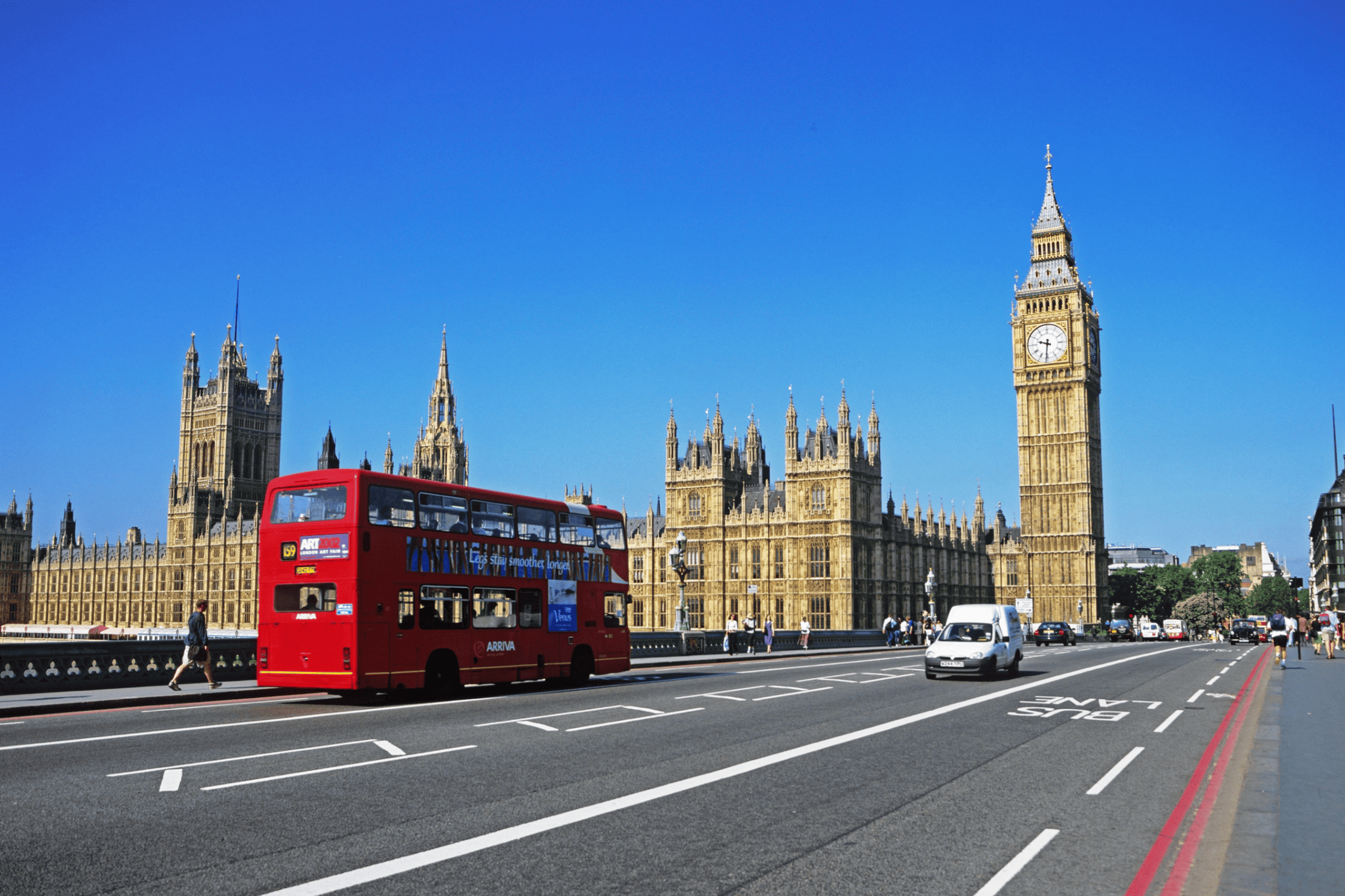 A classic view of a red double-decker bus passing Big Ben in London, representing travel for a hair transplant at the Farjo Hair Institute.